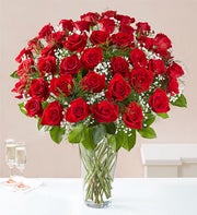 /three dozen roses in glass vase