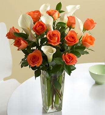 orange roses and white callas in a vase